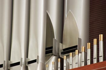 Close up of organ small pipes with large pipes behind